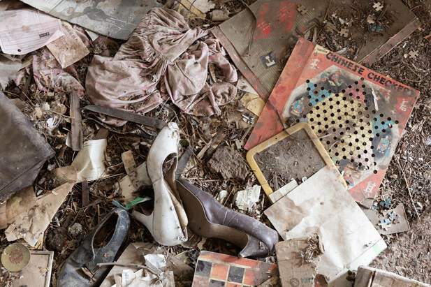 clothes and games left on the floor in an abandoned farmhouse